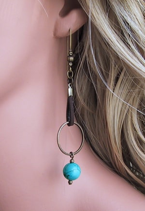 Boucles d'oreille en turquoise véritable et cuir chocolat, très longues, de 9cm environ, dans la tendance shopping actuelle. Bijou fantaisie haut de gamme dans les tons turquoise et chocolat. Sans nickel, hypoallergénique. Bijou de créateur fabriqué en France.