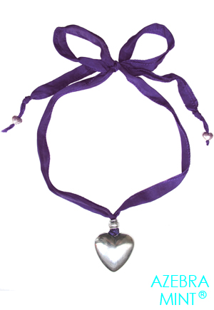 Collier coeur sur soie Violet Anzin. Collier grand coeur argenté de 30mm. Ce collier est monté sur un cordon de soie de coloris violet d'une très grande longueur permettant de le porter à la longueur souhaitée. Ce collier est composé d'un grand pendentif coeur argenté de 30mm, de deux petits coeurs travaillés à chaque extrémités du cordon...