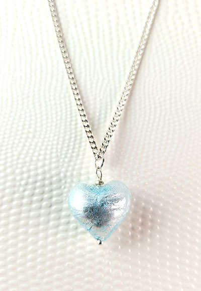 Lumineux et éclatant, ce pendentif en forme de coeur est soufflé à la bouche et tapissé d'argent coloris bleu ciel. Ce pendentif est accompagné d'une chaine plaquée argent de 45cm environ. Ce collier est un bijou magnifique à porter avec des tenues bleues, blanches ou noires. Bijou fantaisie de créateur. Une belle idée de cadeau d'amour.