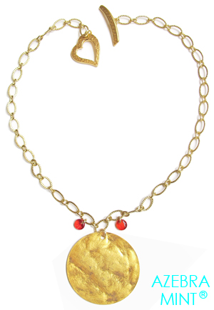 Collier coeur doré Coucher de soleil. Collier doré à grand pendentif rond doré légèrement martelé éclatant comme un soleil. Ce collier est muni d'un charmant fermoir martelé en forme de coeur. Ce collier est composé d'une chaîne dorée et d'un fermoir coeur de 22mm recouverts d'or véritable, d'un pendentif martelé doré de 40mm et de perles...