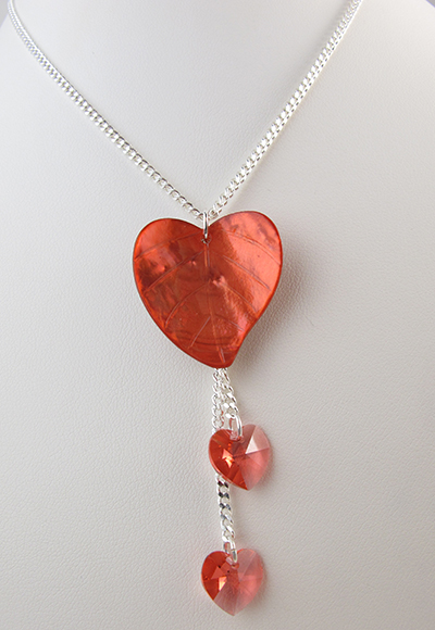 Collier mon cœur d'amour. Perle en nacre rouge léger et cœurs en cristal scintillant.